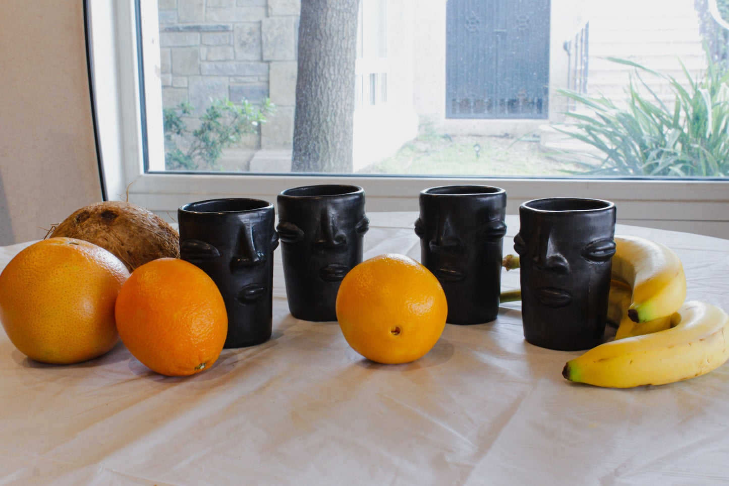 Vasos de barro negro con diseño de cara