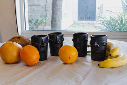 Vasos de barro negro con diseño de cara