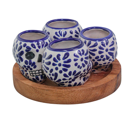 Set de 4 tequileros de talavera con forma de calavera y base de madera redonda