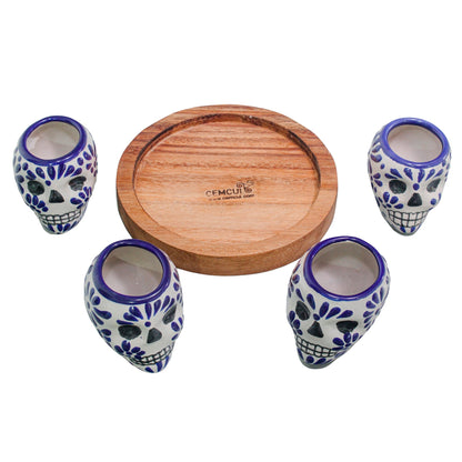 Set de 4 tequileros de talavera con forma de calavera y base de madera redonda